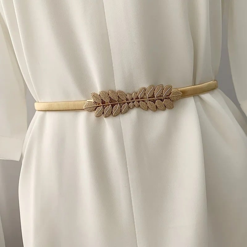 Ceinture Dorée Ornée d'une Boucle en Forme de Laurier mise autour d'une robe blanche